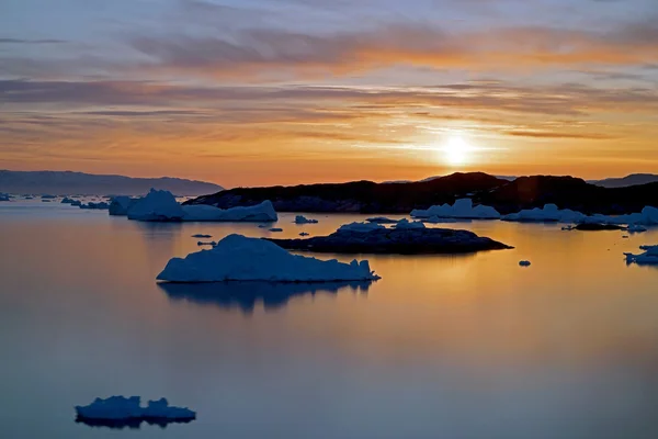 Enormes icebergs están en el océano Ártico en Groenlandia en la hora de la puesta del sol —  Fotos de Stock