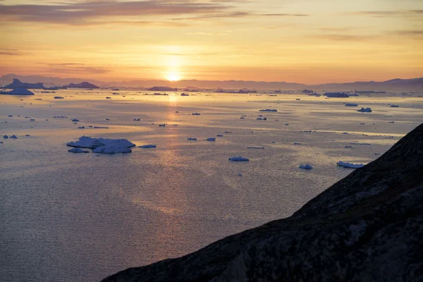 Riesige Eisberge liegen bei Sonnenuntergang auf Grönland im arktischen Ozean — Stockfoto