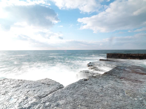 Tiro de exposição longa em rochas com ondas do mar — Fotografia de Stock