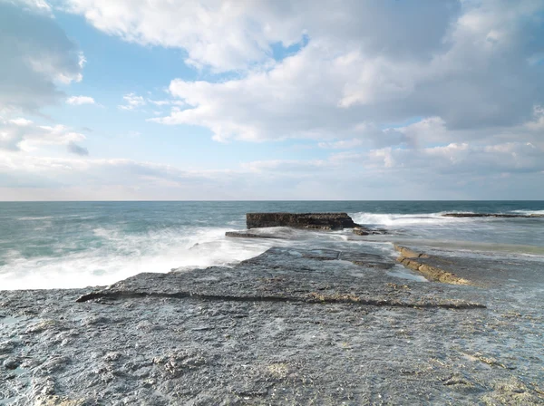 Tiro de exposição longa em rochas com ondas do mar — Fotografia de Stock