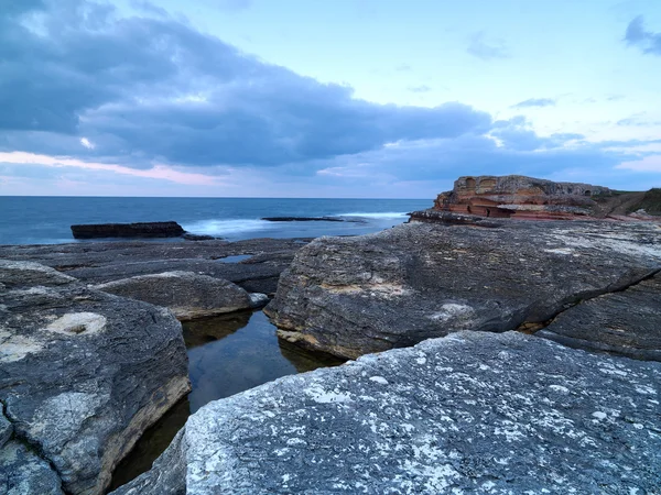 Tiro de exposição longa em rochas com ondas do mar — Fotografia de Stock