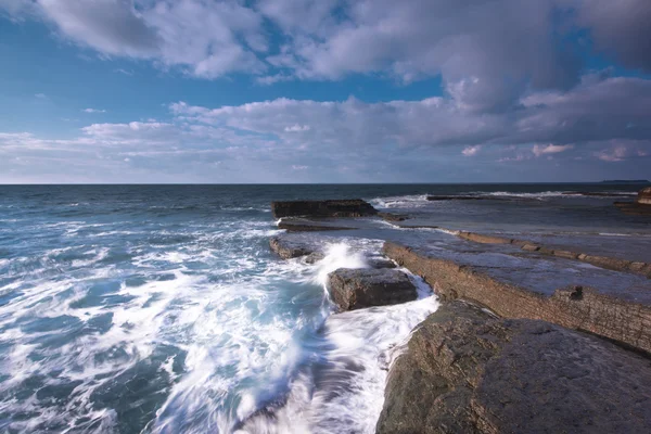 Paisagem de exposição longa em rochas com ondas do mar — Fotografia de Stock