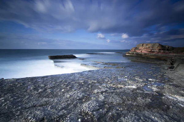 Paisagem de exposição longa em rochas com ondas do mar — Fotografia de Stock