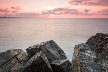 güzel kayalar ve deniz gökyüzü üzerinde büyük bulutlar ile