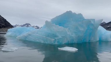 Büyük yüzen buzullar Grönland 'daki buzul kutup okyanusu boyunca yayılarak el değmemiş kutup manzarasını ve değişen iklimin etkilerini vurguluyor..