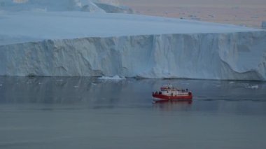 Ilulissat Icefjord, Grönland 'ın sakin Arktik sularında yüzen devasa buzdağlarının çarpıcı manzarası. Icefjord, nefes kesen manzaraları ve etkileyici Ilulissat Buzulu 'nun okyanusa dökülmesiyle bilinen bir UNESCO Dünya Mirası alanıdır.