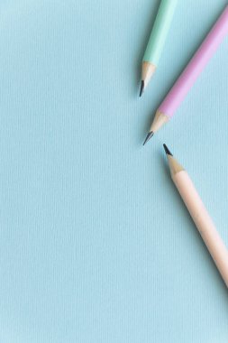 Pastel renkli kalemler boş çarşafta, mavi tonda.