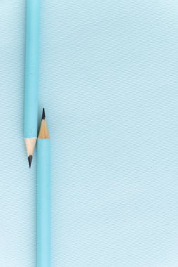 Pastel renkli kalemler boş çarşafta, mavi tonda.
