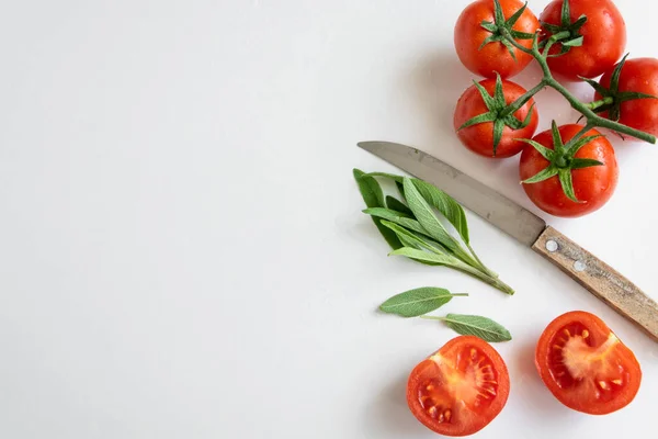 Sağlıklı gıda arka planı - beyaz arka planda çiğ domates ve yabani otlar, canlı renkler, vitamin yiyecekler