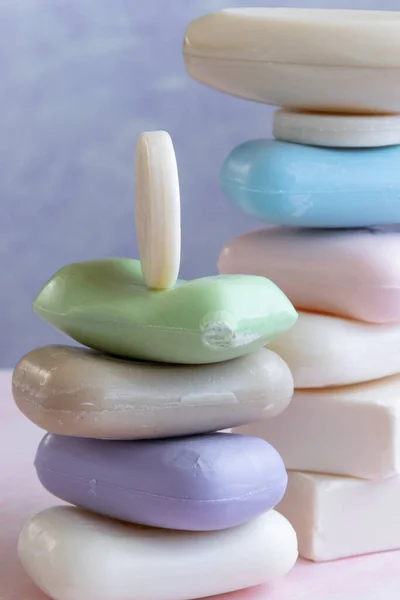 Pembe arka planda farklı el yapımı sabunlar. Hijyen, zanaat ürünleri