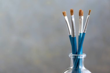 Gri arkaplanda boya fırçaları, sanatsal zanaat kavramı, metin için boşluk