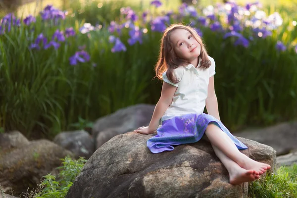 Menina bonita sentada no jardim rockin . — Fotografia de Stock