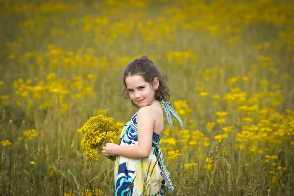 Menina bonita colhendo flores em um dia ensolarado — Fotografia de Stock