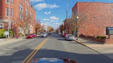 Bir araba Martinsburg, Batı Virginia 'nın büyüleyici sokaklarında geziniyor. Güzel binalar ve açık gökyüzü sergiliyor..