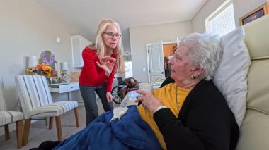 Yaşlı bir kadının bir huzurevini ziyaret ederken kızıyla konuşması, gülümsemesi ve sohbeti paylaşması dokunaklı bir andı..