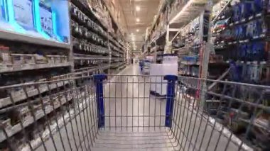 Winchester VA, ABD - 11 28 2025: Bir alışveriş arabasını iterken çeşitli ürünleri sergileyen geniş bir hırdavatçıda hızlı bir yolculuk deneyin.