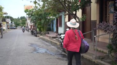 Olgun kadın Nikaragua 'daki Ometepe Adası' nın canlı atmosferinin ve yerel mimarisinin tadını çıkararak Altagracia 'da gezinir..