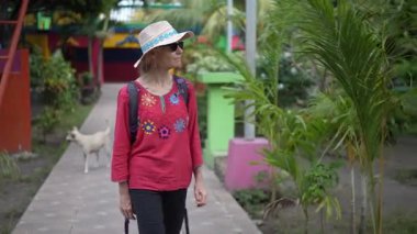 Olgun bir kadın Altagracia, Ometepe Adası 'nın renkli sokaklarında yürüyor, yerel manzaranın ve dost canlısı atmosferin tadını çıkarıyor..