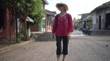 Olgun bir kadın Nikaragua 'daki Ometepe Adası' nın canlı kültürünün ve manzarasının tadını çıkararak Altagracia 'da gezinir..