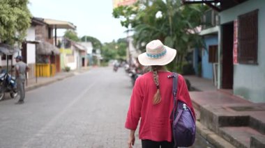 Olgun bir kadın Nikaragua 'daki Ometepe Adası' nın eşsiz cazibesinin ve güzelliğinin tadını çıkararak Altagracia 'nın sessiz sokaklarında yürüyor..