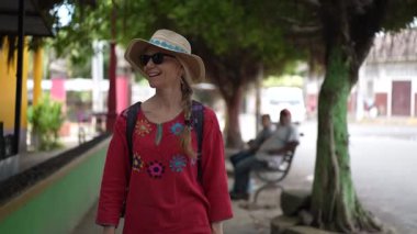 Olgun bir kadın neşeli bir şekilde Altagracia 'da yürüyor, Ometepe, Nikaragua' daki canlı atmosferin ve yerel çevrenin tadını çıkarıyor..