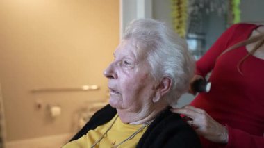 Yaşlı bir kadın, ev sağlık hizmetlerinde çalışan bir personelden nazik bir bakım ve bakım görür, nezaket ve destek gösterir..