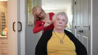 Evde bakım merkezindeki yaşlı bir kadın, kişisel bakım ihtiyaçlarına odaklanan bir bakıcıdan nazik bir bakım görür..