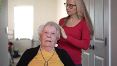 Yaşlı bir kadın, konfor ve refahı teşvik etmek amacıyla, bir ev sağlık merkezindeki bir personelden nazik bir bakım ve ilgi görür..