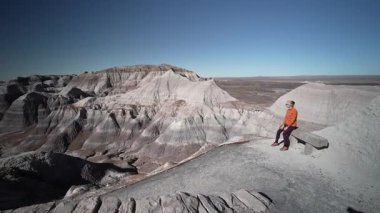 Olgun bir kadın, Arizona 'daki Petrified Forest Ulusal Parkı' nda Mavi Mesa 'da yürüyüş yapar ve manzaranın geniş manzarasını seyreder..