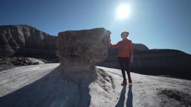 Olgun bir kadın Arizona 'daki Petrified Forest Ulusal Parkı' nın Mavi Mesa bölgesini keşfederken doğa ve doğanın tadını çıkarıyor..