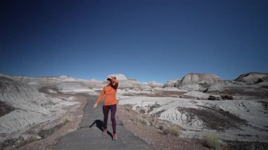 Olgun bir kadın Arizona 'daki Petrified Forest Ulusal Parkı' nın Mavi Mesa bölgesinde doğal manzaranın tadını çıkartıyor..