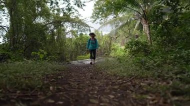Olgun bir kadın Nikaragua 'daki Ometepe Adası' ndaki Charco Verde Parkı 'nda yemyeşil ve vahşi yaşamla çevrili patikaları keşfediyor..