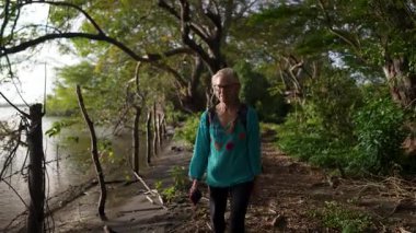 Kadın Nikaragua 'daki Ometepe Adası' ndaki Charco Verde Parkı 'nda yürüyor güneşli bir öğleden sonra ormanın ve doğanın tadını çıkarıyor..