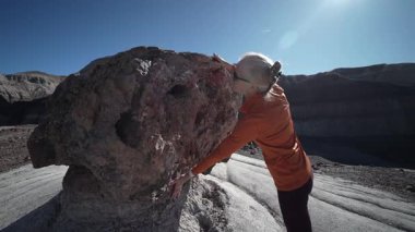 Olgun kadın, Arizona 'daki Taşlaşmış Orman Ulusal Parkı' nın Mavi Mesa bölgesinde yürüyüş yapmaktan hoşlanıyor. Büyük kaya oluşumlarıyla etkileşime geçiyor..