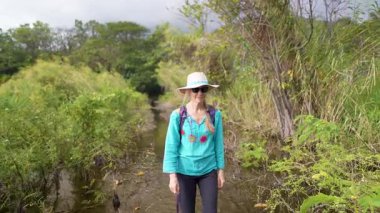Olgun bir kadın Nikaragua, Ometepe Adası 'ndaki Charco Verde parkında yürüyüş yapar ve ormanın güzelliğinin tadını çıkarır..