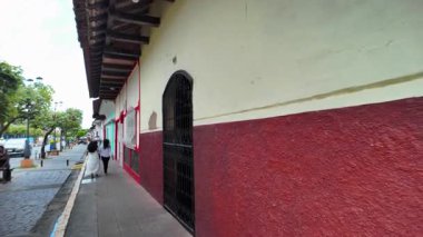 Granada Nikaragua 'nın sömürge caddelerinde yürürken renkli binalar ve günlük yaşamlarıyla meşgul olan yerel insanlar görülüyor..