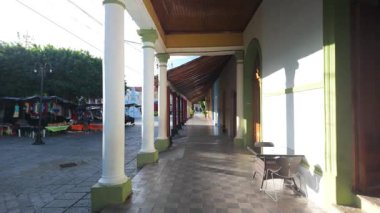 Koloni Granada Nikaragua 'sının cazibesini keşfedin. İnsanlar öğleden sonra dükkan ve kafelerle dolu caddelerde yürürken..