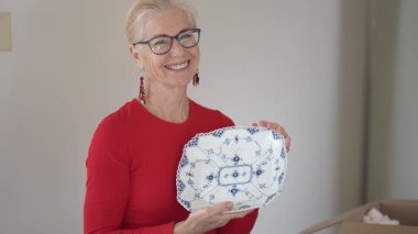 Bir kadın miras kalan porselen yemek takımlarını açarken aile yemeklerini hatırlıyor ve çocukluk anılarını anlatıyor..