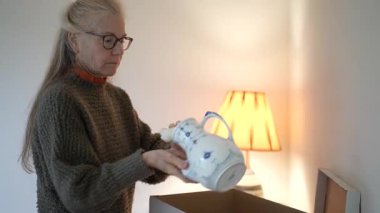 Olgun bir kadın aile antikalarının olduğu kutuları açar ve sıcak bir oturma odasında geçmişinden kalan anıları canlandıran yadigarları ortaya çıkarır..