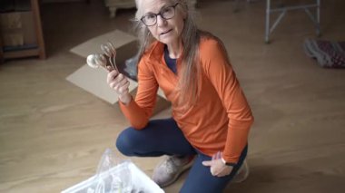 Olgun bir kadın gümüş çatal bıçak parçalarını inceler, aile anılarını ve kalıtsal aile yadigarlarıyla ilgili duygularını hatırlar..