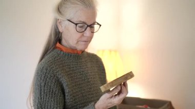 Olgun bir kadın aile kutularını açar ve antikaları ve aile yadigarlarını geçmişten özel anılar ve hikâyelerle keşfeder..