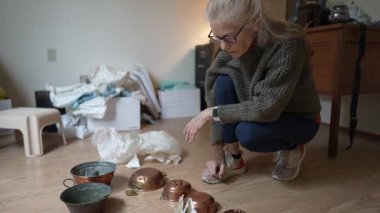 Olgun bir kadın, aile hazinelerini ve aile yadigarlarını araştırırken, miras kalan bir haritaya yakından bakar..
