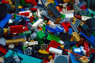 Bu yukarıdan aşağıya bakış açısı birbirine kenetlenmiş renkli plastik oyuncak tuğlaları ve tekerlek ve minyatür figürler gibi çeşitli aksesuarları gösteriyor. Canlı renkler ve çeşitli şekiller çocuklarda oyun zamanı yaratıcılığı ve iyi motor becerileri teşvik eder..