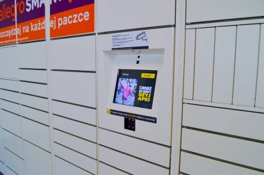 Ticari paketleri almak ve göndermek için kullanılan beyaz otomatik dolap terminalinin yakın çekim görüntüsü. Sistem, içinde talimatlar bulunan parlak bir dijital ekran ve hızlı kullanıcı erişimi için QR kod tarayıcısı içeriyor. Bu teknoloji