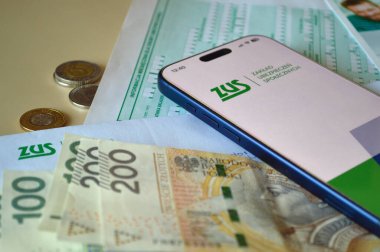 ZUS uygulama logosunu gösteren modern bir akıllı telefon Polonya para birimi notları ve resmi vergi belgelerinin üzerine yerleştirilir. Sahne, Polonya 'daki dijital sosyal güvenlik yönetimi ve emeklilik planlarını gösteriyor. Bu resim finans için uygundur