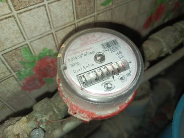 Rudny, Kazakistan - 10 Kasım 2025. Su sayacı boruya yakın çekim için takıldı. Soğuk ve sıcak su tüketimini. Su tasarrufu. Artan su fiyatları kavramı