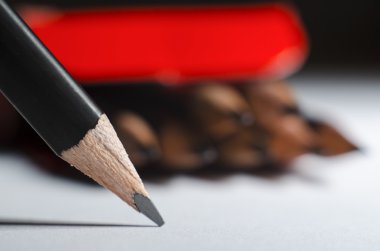 grafit kalem boya kalemleri ve bir siyah arka plan, makro bir kutu bir arka plan üzerinde beyaz bir kağıda