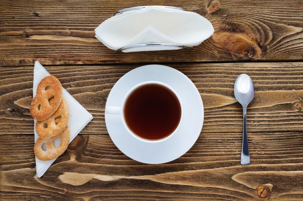 Çay ahşap bir masa, şeker, kaşık, bisküvi, peçete, üstten görünüm