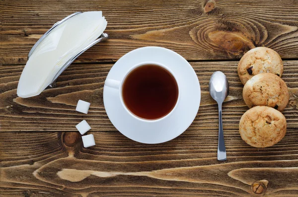 Çay ahşap bir masa, şeker, kaşık, bisküvi, peçete, üstten görünüm