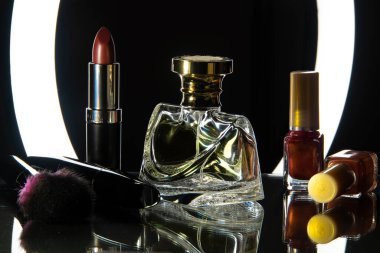 Parfüm, kozmetik ürünleri, oje ve lamba açık siyah bir masada fırça. Siyah arkaplan.